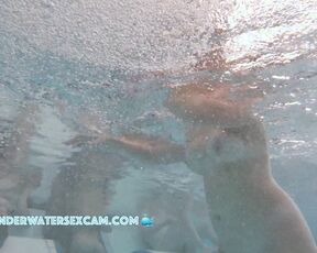 This young couple plays together underwater in front of many people
