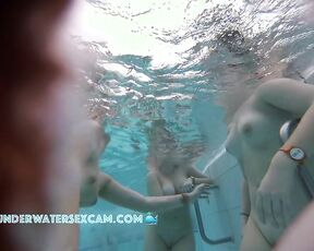 A group of young women show their naked bodies underwater in the sauna pool