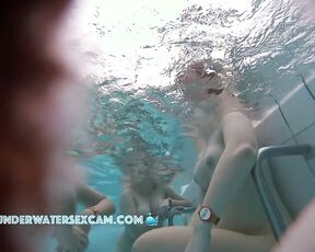 A group of young women show their naked bodies underwater in the sauna pool