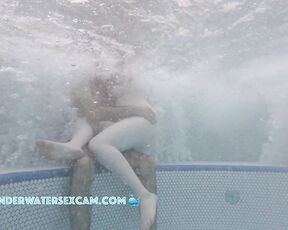 A very white girl hangs out on a very brown boy while the jacuzzi is running