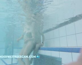 A pretty young couple talking while nude on an underwater bench