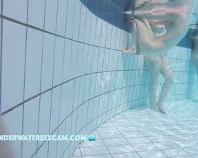 A really pretty naked girl holds on to the edge of the pool and is being filmed underwater with a hidden camera.