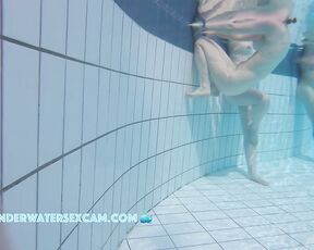 A really pretty naked girl holds on to the edge of the pool and is being filmed underwater with a hidden camera.