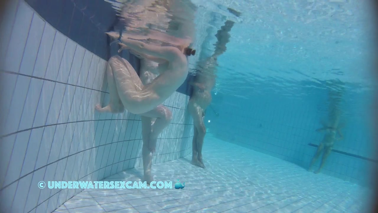 A really pretty naked girl holds on to the edge of the pool and is being filmed underwater with a hidden camera.