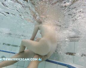 NEW! A young couple plays together in a large public jacuzzi.