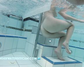 NEW! A young couple plays together in a large public jacuzzi.