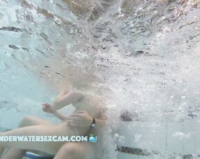NEW! A young couple plays together in a large public jacuzzi.