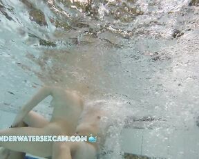 NEW! A young couple plays together in a large public jacuzzi.
