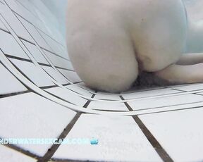 This delicate girl is trying out the massage jets in the underwater loungers.
