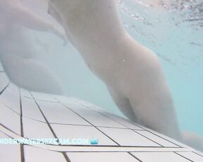 This delicate girl is trying out the massage jets in the underwater loungers.