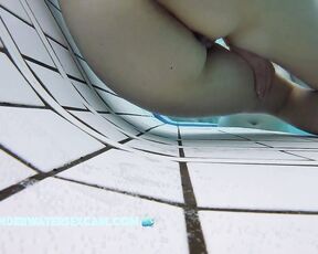 This delicate girl is trying out the massage jets in the underwater loungers.